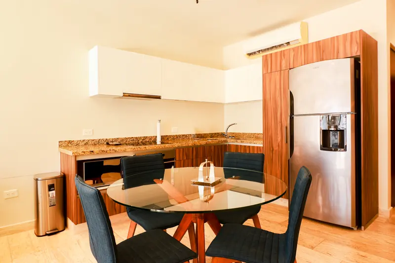 Comedor para cuatro y cocina con cubierta de granito y refrigerador