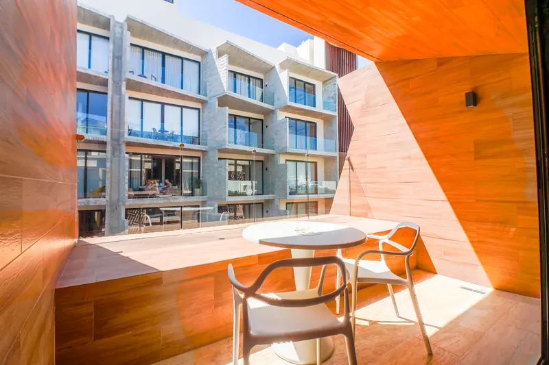 Terraza revestida en madera con mesa y dos sillas